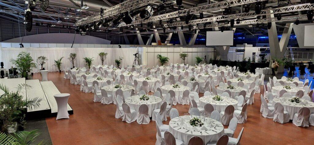 Großer Veranstaltungsraum mit eleganten Tischen und Stühlen für ein festliches Event