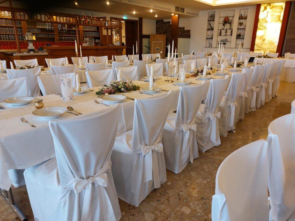 Lange Hochzeitstafel mit weißen Tischdecken und Stuhlhussen mit Schleife zum Mieten – Eleganter Hussen-Verleih in Salzburg und ganz Österreich