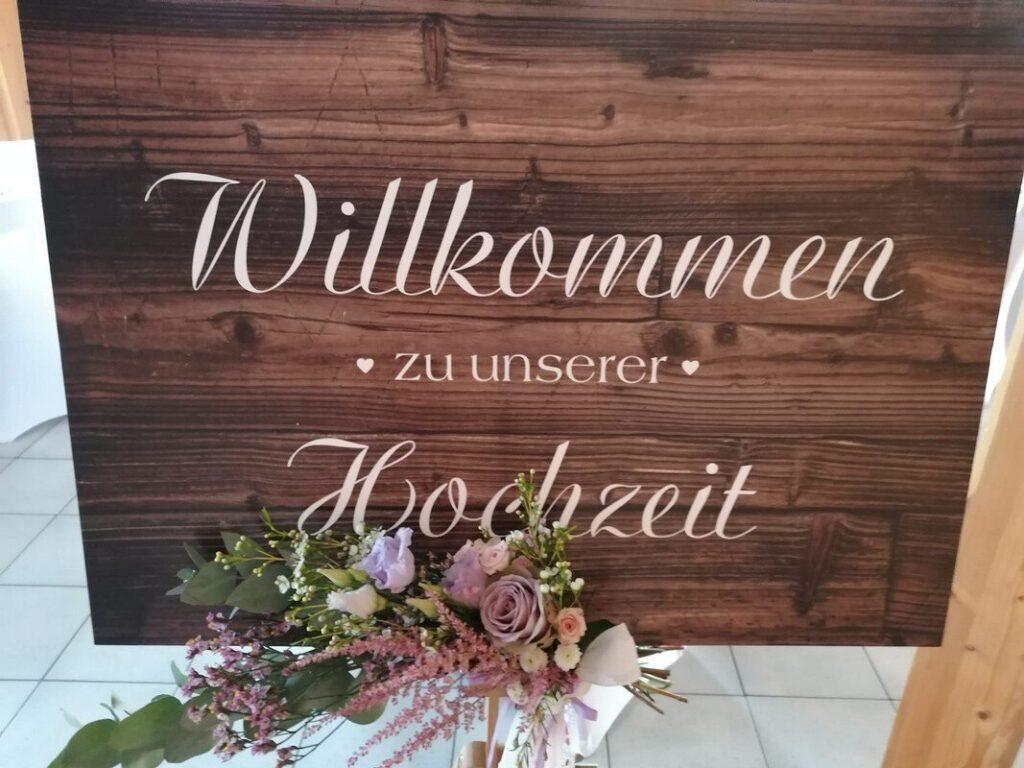 Willkommensschild zur Hochzeit mit romantischen Blumenarrangement